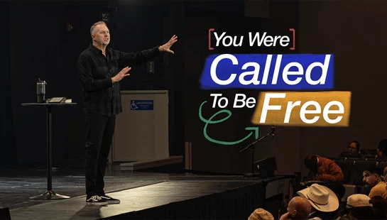 A male pastor in a dark plaid shirt preaches on a stage. To the right, text overlay reads, 'You Were Called To Be Free' as an audience watches.